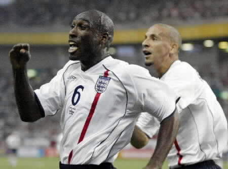 Sol Campbell (L) of England is followed by Rio Ferdinand as they celebrate England's first goal against Sweden.