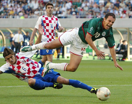 Croatia's Boris Zivkovic (L) brings down Mexico's Cuauhtemoc Blanco as Croatia's Zvonimir Soldo looks on during the second half of their Group G match of the World Cup finals between Mexico and Croatia in Niigata June 3, 2002. Zivkovic became the first player to be sent off in the 2002 World Cup, and Blanco later scored with a penalty. Mexico won 1-0.