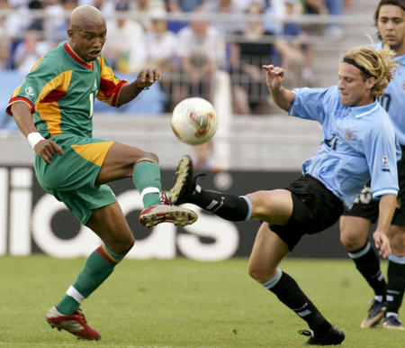 Senegal's El Hadji Diouf (L) and Uruguay's Diego Forlan fight for the ball during their World Cup Finals match in Suwon, June 11, 2002