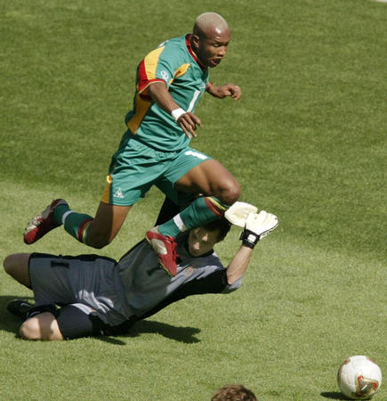 Uruguay goalkeeper Fabian Carini (bottom) trips Senegal's El Hadji Diouf in the penalty box during a World Cup Finals match in Suwon, June 11, 2002