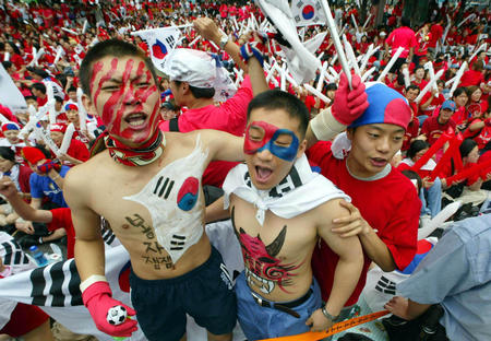 South Korean soccer fans cheer their team as they gather to watch the World Cup Finals match between USA and South Korea on a huge public television screen in central Seoul June 10, 2002