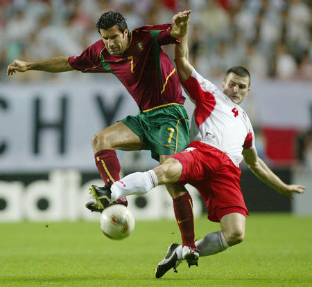 Portugal's Luis Figo (L) leaps to challenge Poland's Michal Zewlakow (R) for the ball during their World Cup Finals match in Chonju, June 10, 2002