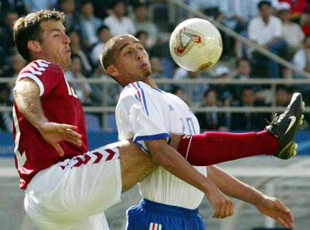 Denmark's Niclas Jensen (L) challenges France's David Trezeguet in the second half of a Group A match at the World Cup Finals in Inchon June 11, 2002