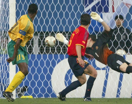 South Africa's Lucas Radebe (L) shoots and scores against Spanish goalkeeper Iker Casillas during their World Cup Finals match in Taejon, June 12, 2002