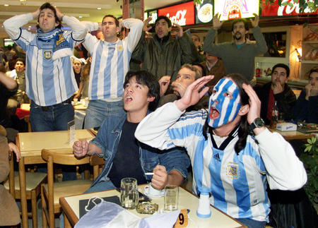Argentine soccer fans react while watching Argentina play Sweden in World Cup action in a bar of Buenos Aires, June 12, 2002. Argentina and Sweden tied at 1-1, forcing Argentina out of the 2002 FIFA World Cup after the first round