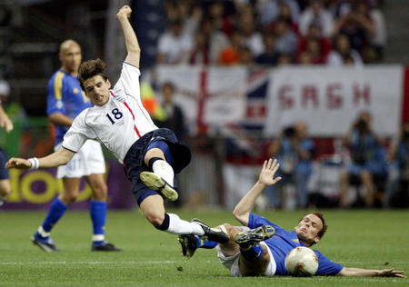 England's Owen Hargreaves (18) and Sweden's Fredrik Ljungberg (R) fall as they fight for the ball during their group F match at the World Cup Finals in Saitama June 2, 2002.
