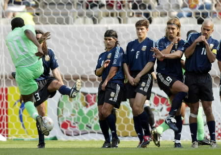 Nigeria's Jay Jay Okocha (L) delivers a free kick as Argentina's (R-L) Juan Veron, Gabriel Batistuta, Javier Zanetti, Ariel Ortega and Juan Sorin protect themselves during their Group F match.