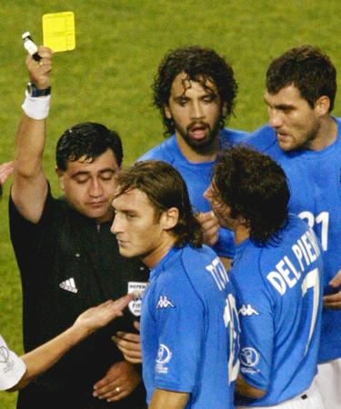 Italy's Francesco Totti (2nd L) receives a yellow card from referee Byron Moreno as team mates Alessandro del Piero (2nd R), Christian Vieri (R) and DamianoTommasi (top) argue during their second round World Cup Finals match against South Korea in Taejon June 18, 2002