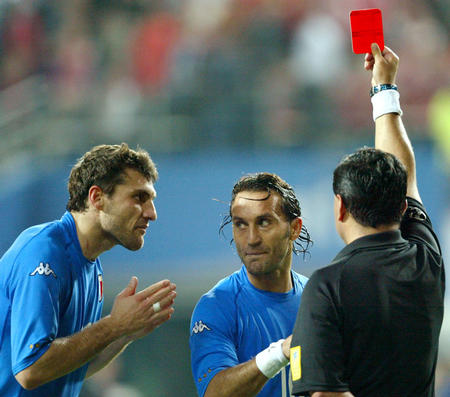 Italy's Angelo Di Livio (C) looks over at team mate Christian Vieri (L) as referee Byron Moreno (R) of Ecuador gives a red card to Italy's Francesco Totti in extra time against South Korea during a second round World Cup Finals match in Taejon, June 18, 2002. South Korea won 2-1