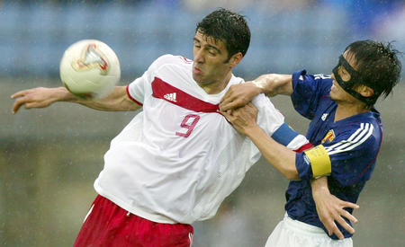 Turkey's captain Hakan Sukur (L) fights for the ball against Japan's captain Tsuneyasu Miyamoto during the second round World Cup Finals match between the two countries in Sendai June 18, 2002