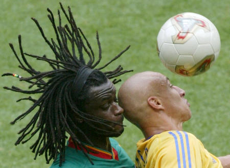 Senegal's Ferdinand Coly (L) competes for a header with Sweden's Henrik Larsson during their second round match at the World Cup Finals in Oita June 16, 2002